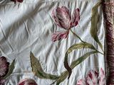 a bed with a white and pink floral comforter on it