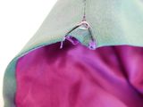 close up of the zipper of a purple and green jacket