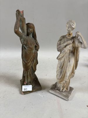 trois statues représentant une femme et un homme tenant une croix