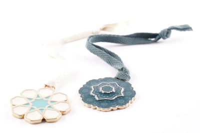 two necklaces with a flower on a string on a white background