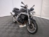 une moto noire garée sur un sol à carreaux noirs et blancs