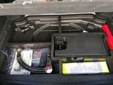 an open trunk of a car with a small device in it