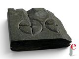 a stone with a cross on it on a white surface