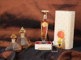 un flacon de parfum et une boîte de parfums posés sur un lit