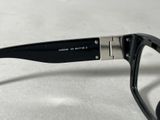 glasses with a black frame and a silver rim sitting on a white surface