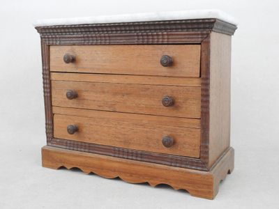 a small wooden chest of drawers with a marble top