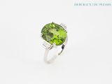 a close up of a ring with a green stone on it