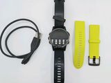 une montre noire avec un bracelet jaune sur un fond blanc