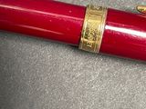 a red pen that is laying on top of a table