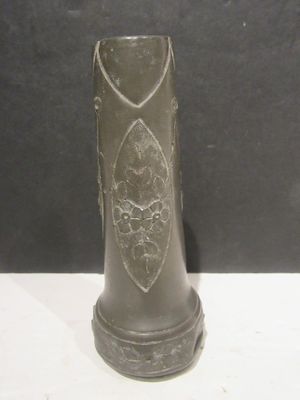 un vase noir orné d'un motif, posé sur une table