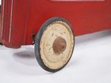 a red toy car that is sitting on a white surface