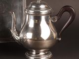 a silver tea pot sitting next to a mirror