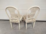 pair of white chairs with floral upholstered seats in front of a garage door