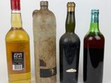 four bottles of alcohol are lined up on a white surface