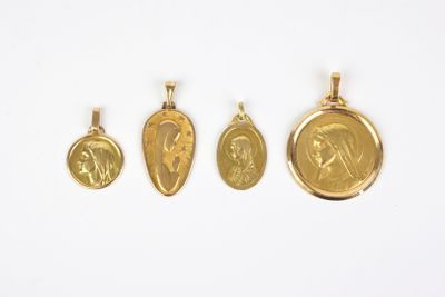 three gold pendants of jesus and mary on a white background