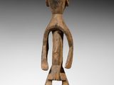 une statue en bois d'un homme avec un chapeau sur la tête