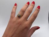 woman ' s hand with red manicured nails and a gold ring