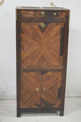 une armoire en bois à deux portes, avec un tiroir en dessous