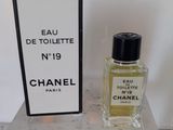Flacon et coffret de parfum « Eau de Toilette » de Chanel posés sur une table en marbre