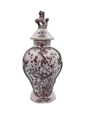 a brown and white vase with a bird on top of it