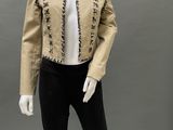 a mannequin wearing a gold jacket and black pants