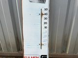 a white thermometer sitting on the side of a building
