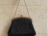 le sac à main noir est accroché au mur, à côté du mur