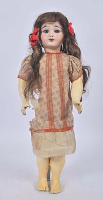 an old doll with long hair wearing a dress and a red flower in her hair