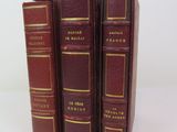 three books are stacked on top of each other on a white surface