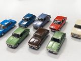 plusieurs petites voitures sont alignées sur une surface blanche