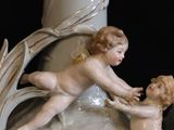 a statue of a boy and a girl playing on a vase