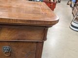 a wooden table with a drawer on it in a store