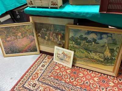 trois photos encadrées posées par terre à côté d'un tapis