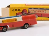 un camion jouet rouge qui se trouve à côté d'une boîte jaune