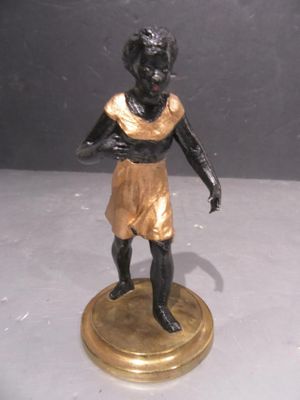 a bronze statue of a boy standing on a pedestal