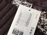 a tag that is attached to a sweater on a hanger