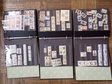 four binders with stamps on them on a wooden floor
