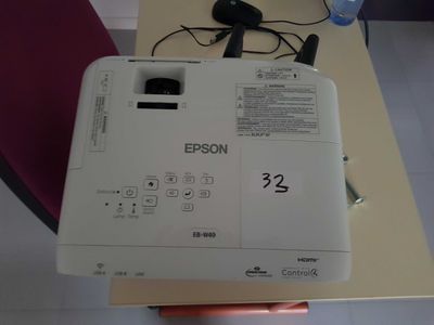 a white projector sitting on top of a wooden table