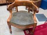 a wooden chair with a green seat in a room