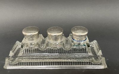 trois salières et poivrières en verre posées sur un plateau transparent