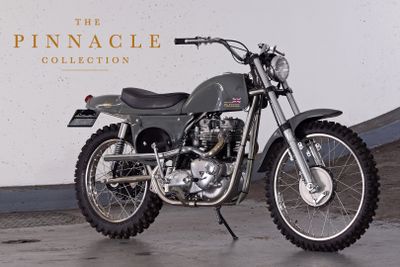 a motorcycle that is parked in front of the pinnacle collection sign