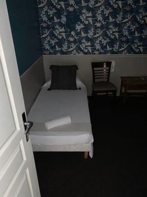 un petit lit dans une petite chambre avec du papier peint bleu