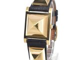 a black and gold watch on display on a clear surface