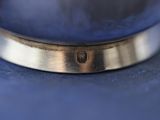 a close up of a silver ring on a blue cloth