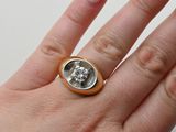 a woman ' s hand holding a ring with a diamond on it