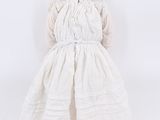 a small doll that is wearing a white dress