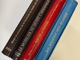 four books on a table that are sitting on top of each other