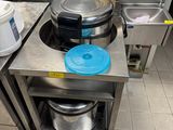 une cuisine équipée d'une cuisinière, d'un évier et de casseroles posées sur le plan de travail