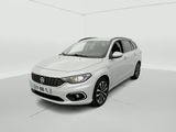 Une voiture blanche est garée dans une pièce blanche au sol blanc.