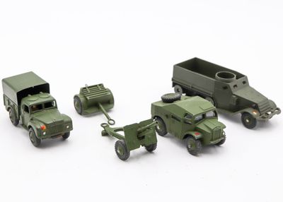 three toy army vehicles and a truck on a white surface